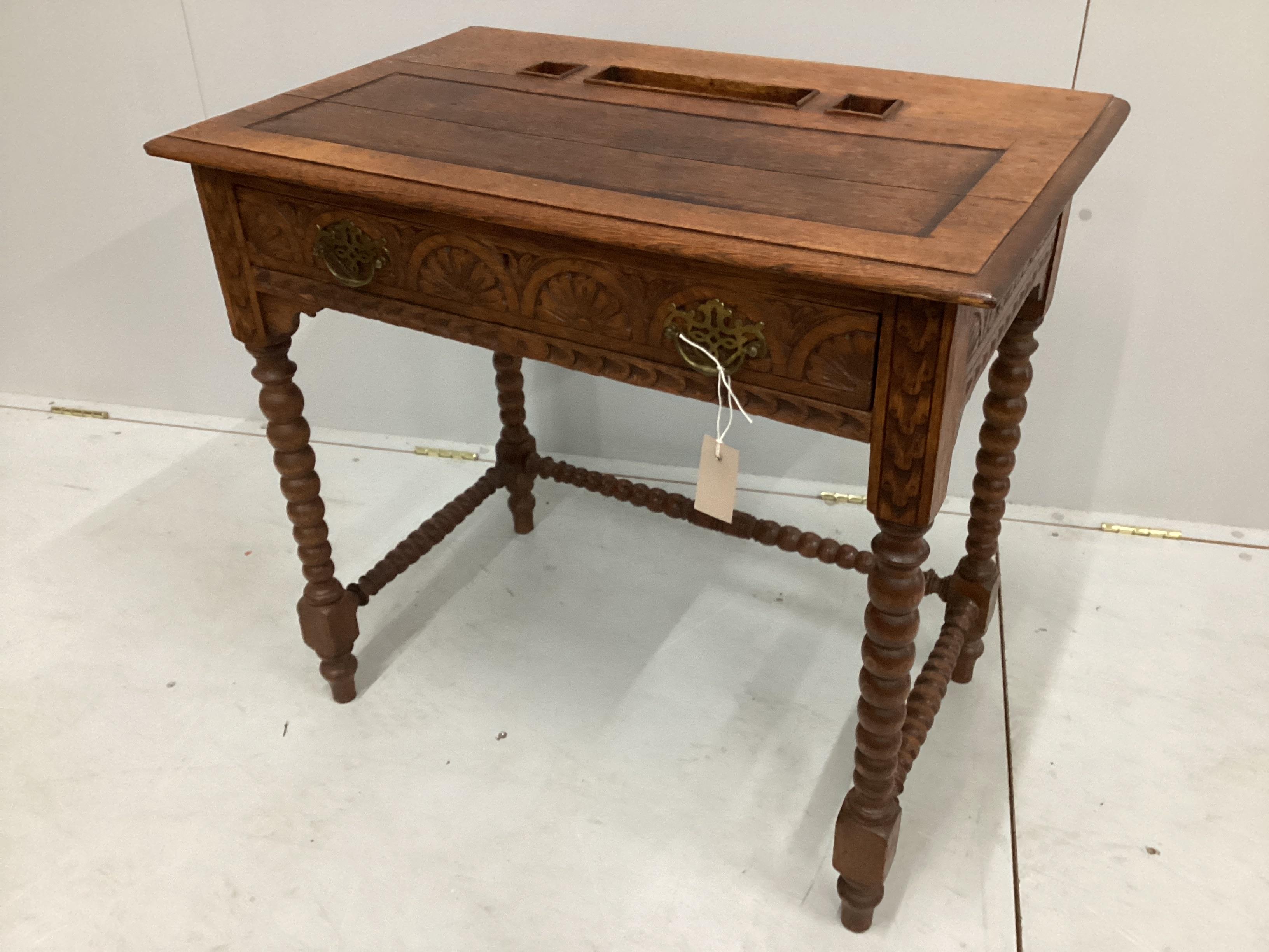 A late 19th / early 20th century lunette carved oak writing table on bobbin legs, width 75cm, depth 48cm, height 70cm